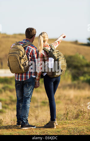 rear view of hikers pointing at distance Stock Photo