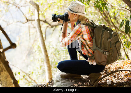 young woman taking photos in forest Stock Photo