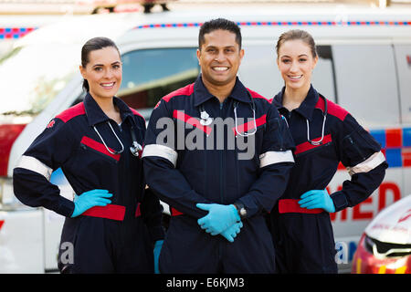 group of paramedics standing in front of an ambulance Stock Photo