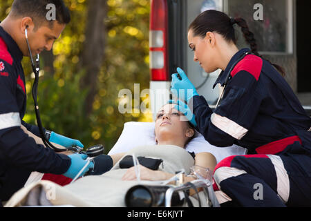 team of emergency medical technicians checking patients vital signs Stock Photo