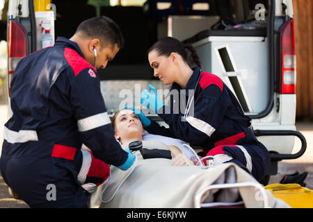 paramedic team examining young female patient Stock Photo