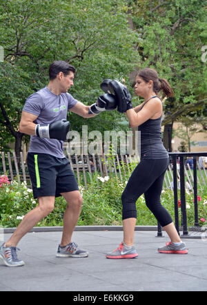 A young man & young woman at a boxing exercise class in Washington Square Park in Greenwich Village, New York City. Stock Photo