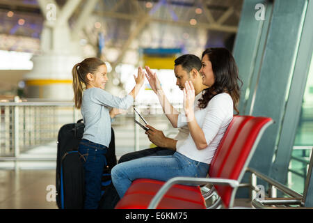 happy mother and daughter playing a game at airport before boarding Stock Photo