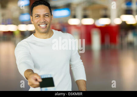 handsome mature man handing over air ticket at check in counter Stock Photo