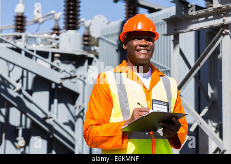 young African technician working in electrical substation Stock Photo