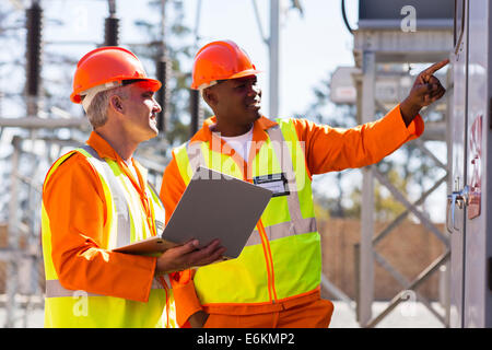 two male engineers working in electrical substation Stock Photo