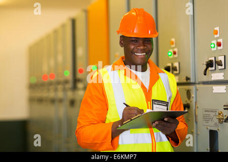 happy African American engineer standing in front of control panel Stock Photo