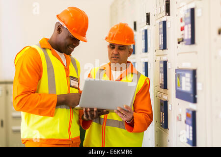 successful technicians using laptop in control room Stock Photo