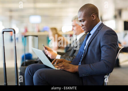 young African American businessman using laptop while waiting for his flight Stock Photo