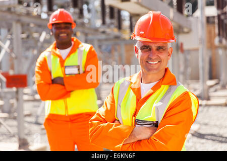 two electricity company workers in substation Stock Photo