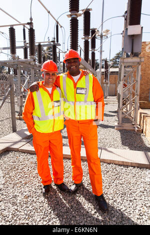 portrait of two electricity workers standing in substation Stock Photo