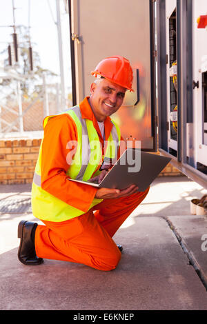 professional senior electrician working in substation Stock Photo