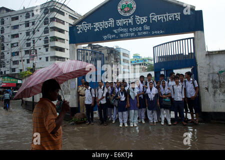 Dhaka, Bangladesh. 26th Aug, 2014. School student wade through the water in a flooded street after a heavy downpour in Dhaka.City dwellers suffer due to the stagnant rain water as the drains and sewage system are poor and lack maintenance.Dhaka is the second most vulnerable city to serious flooding among nine coastal cities around the world and will remain so until 2100 unless measures to counter the threat are taken, suggests an international study Credit:  Zakir Hossain Chowdhury/ZUMA Wire/Alamy Live News Stock Photo