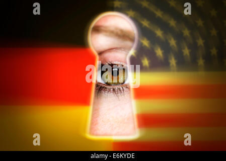 Auge blickt durch ein Schlüsselloch und Nationalfarben von Deutschland und den USA, Spionageaffäre Stock Photo