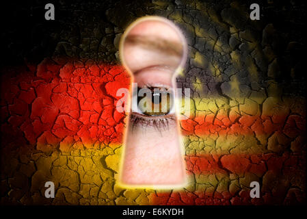 Auge blickt durch ein Schlüsselloch und Nationalfarben von Deutschland und den USA, Spionageaffäre Stock Photo