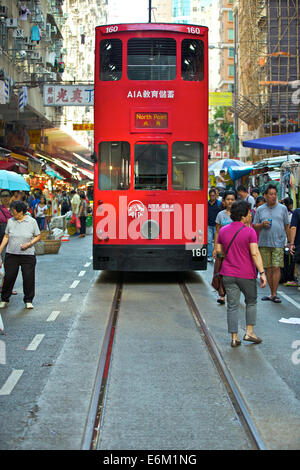 Historic Tram Passes The Street Market On Chung Yeung Street, Hong Kong. Stock Photo