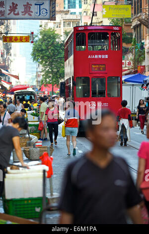 Vintage Tram Passes The Street Market On Chung Yeung Street, Hong Kong. Stock Photo