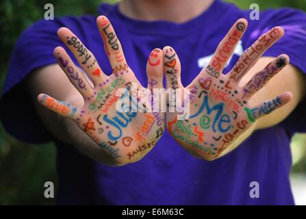 A set of colorful hands painted with words and expressions, highlighting the use of fingers and palms as a medium to communicate meaning visually. This artwork emphasizes the vibrancy of human expression. Stock Photo