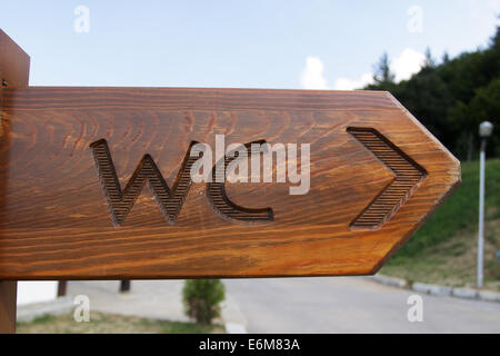 Sign of public toilets WC on wooden plate Stock Photo