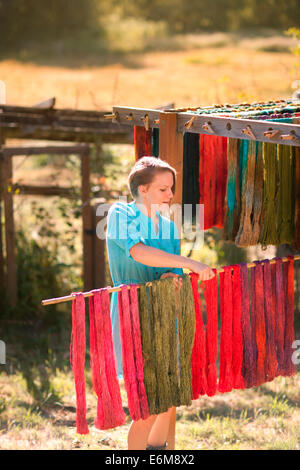 Woman hanging yarn for drying Stock Photo