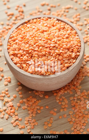 Red lentils in a wooden bowl. Closeup. Stock Photo