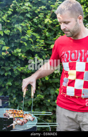 Man cooking meat on the barbecue - right-side Stock Photo