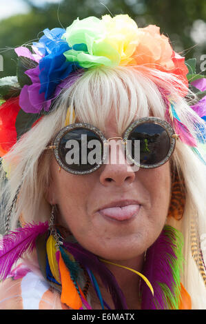 woman with colourful flowers in her hair sticks out her tongue at the victorious festival 2014 southsea england uk Stock Photo