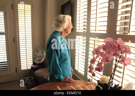 Elderly woman standing in bedroom Stock Photo