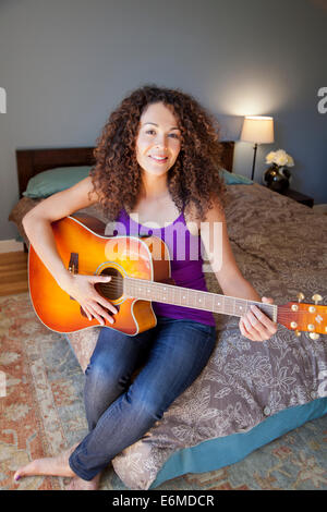 Portrait of woman playing guitar Stock Photo