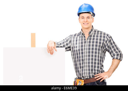 Male repairman leaning on a blank banner isolated on white background Stock Photo