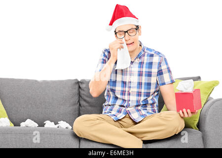 Sad man with Santa hat wiping his eyes from crying isolated on white Stock Photo
