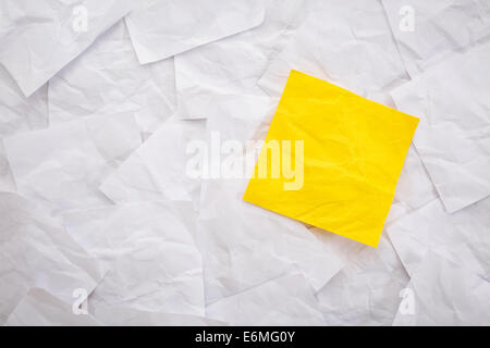 blank yellow sticky note against background of white crumpled notes Stock Photo