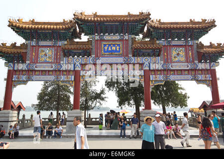 Tourists pose in front of a paifang, a gate based on traditional Chinese architecture. Stock Photo