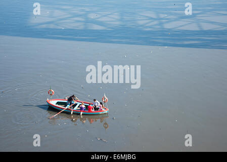 An oarsman crossing people across the Riachuelo river in a wooden rowboat, in La Boca neighbourhood of Buenos Aires, Argentina. Stock Photo