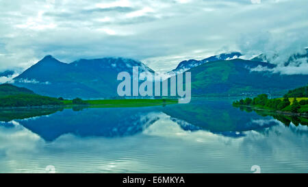 Early morning mist rising from the Glencoe mountains, reflected in Loch Leven, Lochaber, Scottish Highlands, Scotland UK Stock Photo