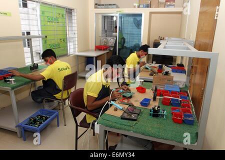 Dhaka, 2014. An employee works on a mother board of a solar optimizer, a key component of solar home systems in Solaric factory in Dhaka. mother board Stock Photo