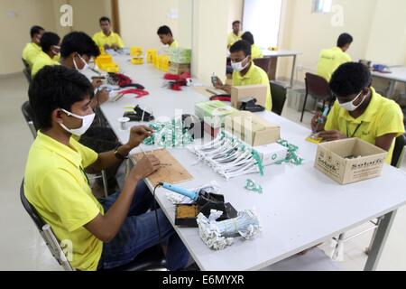 Dhaka, 2014. An employee works on a mother board of a solar optimizer, a key component of solar home systems in Solaric factory in Dhaka. mother board Stock Photo