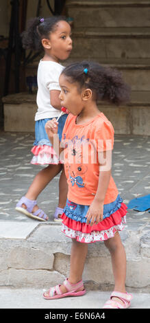 young Cuban girls sucking lollipops, Havana, Cuba Stock Photo