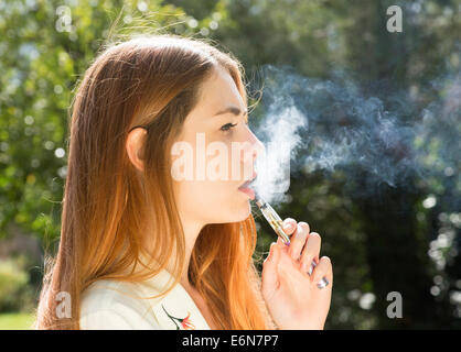 young woman smoking an electronic e-cigarette Stock Photo