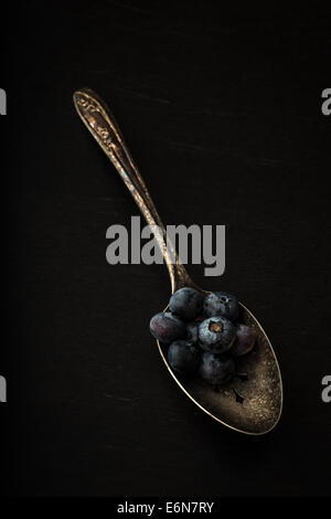 Fresh picked blueberries on a old silver spoon