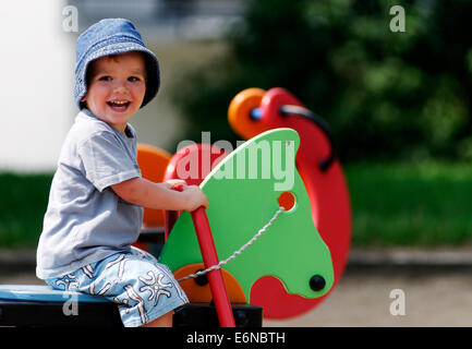 A smiling happy young boy playing in a playground Stock Photo