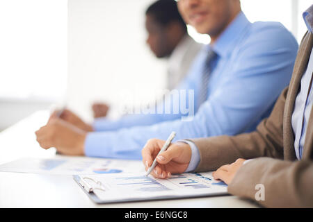 Young businesswoman working with spreadsheet with colleagues on background Stock Photo