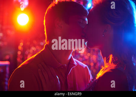 Amorous couple kissing while dancing in the night club Stock Photo