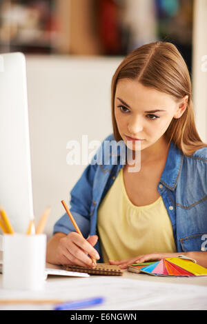 Portrait of pretty designer making sketch in notepad Stock Photo