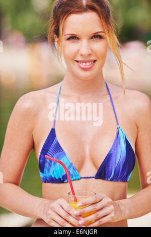 Young woman in bikini holding glass of juice Stock Photo