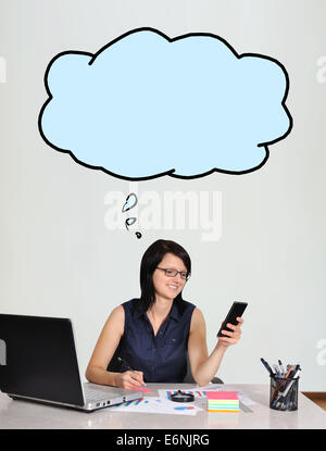 happy businesswoman sitting in office with cloud over head Stock Photo