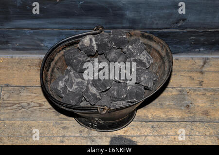 Coal bucket on a wooden floor Stock Photo