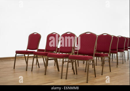 Red chairs in empty conference hall with laminate. Stock Photo