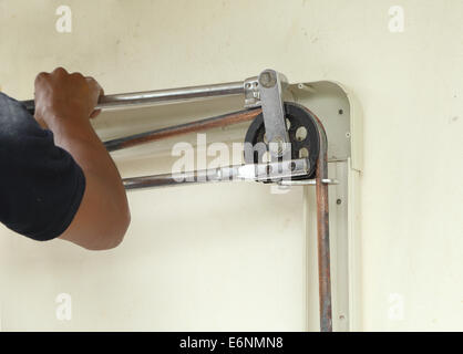 Technician bending length of copper pipe on the wall Stock Photo