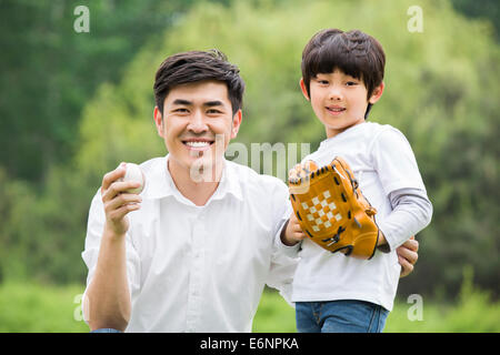 Portrait of young father and son with baseball Stock Photo